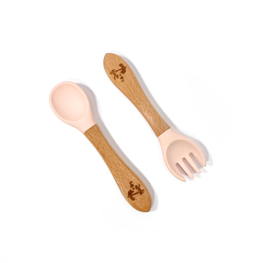 A set of children’s bamboo and silicone cutlery, in a peachy pink colour.