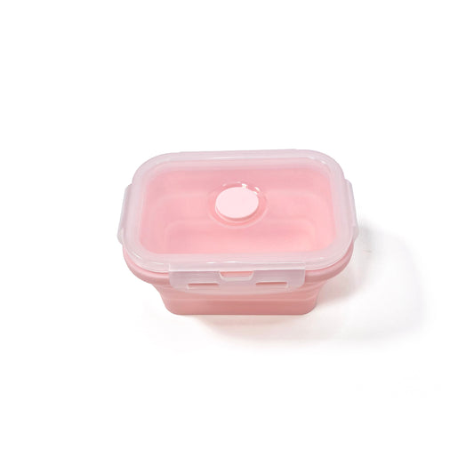  A collapsible pink rectangular silicone food storage tub with lid. View from the side, tub has been fully expanded and has the lid attached.
